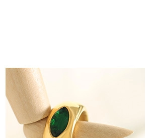 Close-up of vintage gold chunky ring with an emerald green oval gemstone on a model