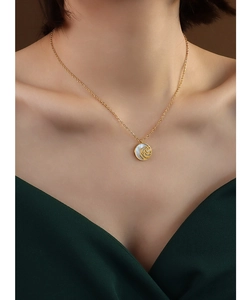 Macro detail of golden rose pendant with mother of pearl inlay and sparkling zircon