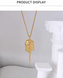 Detailed view of vintage gold-plated necklace with face relief and dangling bead chain