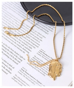 Detail of 18K gold-plated portrait pendant necklace on twisted chain with lobster clasp