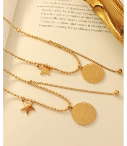 Dettaglio catena a sfere in acciaio placcato oro 18k con stella Luck e ciondolo Good Luck