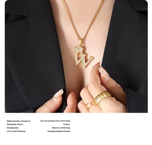 Detail of 18k gold plated titanium steel crown letter W pendant worn with a black suit