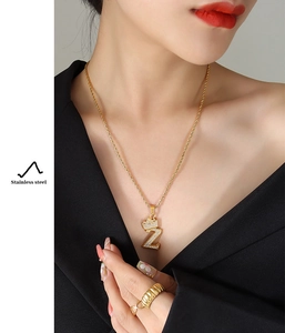 Macro detail of gold-plated stainless steel crown letter Z pendant with white zircons