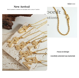Detailed close-up of crown initial pendants with pavé stones and gold twist rope chain