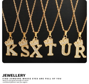 Detail of gold crown initial pendants with pavé zircon settings on rope chains