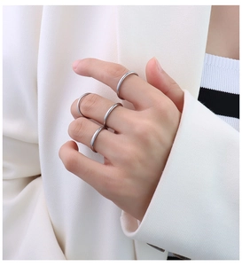 Set di anelli impilabili in argento lucido sulle dita per un look da ufficio chic