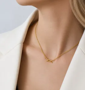 Dettaglio macro del ciondolo a farfalla XO placcato oro 18k stile francese su una modella