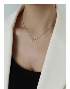 Collana con ciondolo a nodo geometrico argento su modella con blazer bianco