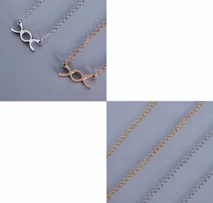Dettaglio del ciondolo in acciaio al titanio chirurgico placcato oro 18K dal design incrociato