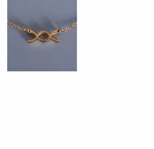 Dettaglio di una collana in titanio placcato oro 18k con ciondolo a forma di fiocco