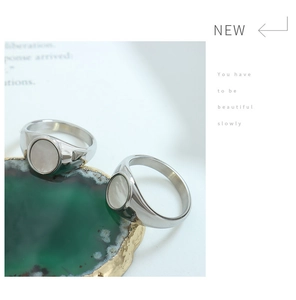 Dettaglio di due anelli in acciaio inossidabile con inserti in conchiglia su pietra agata