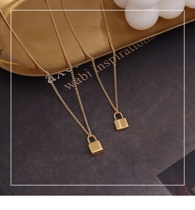 Close-up of golden heart lock pendant necklace on aesthetic minimalist background