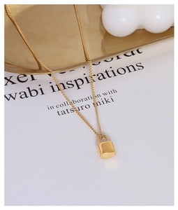 Detailed close-up of a minimalist gold heart lock pendant necklace on a decorative tray