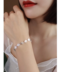 Close-up of minimalist silver smiley face bracelet on wrist with elegant skin texture