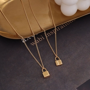 Minimalist gold lock pendant necklaces on a luxury textured dark background setting