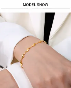 Gros plan d'un bracelet à maillons en S en acier titane plaqué or 18 carats sur le poignet