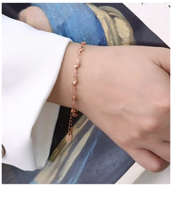 Détail d'un bracelet en acier titane plaqué or 18 carats avec design à ondes chic