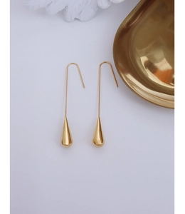 Detailed shot of golden teardrop earrings with a polished surface and long hook design
