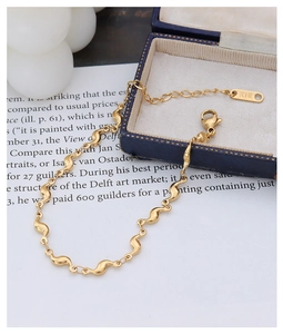 Vue détaillée du bracelet à maillons vagues en or 18K avec fermoir mousqueton et logo K18