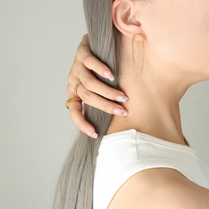 Ensemble de boucles d'oreilles à chaîne en U dorées et bagues texturées sur mannequin