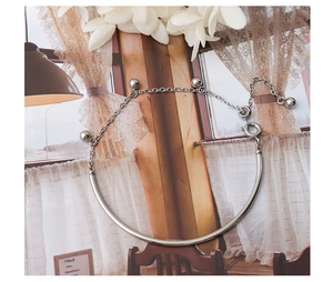 Detail of silver steel bracelet with ball pendants on a lifestyle magazine background