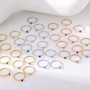 Macro view of assorted heart-shaped birthstones set in gold and silver stainless steel rings
