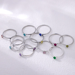 Macro view of twelve heart-shaped colorful birthstone rings in silver finish