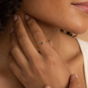 Minimalist 18K gold plated ring featuring a heart-shaped blue zircon stone on model hand