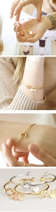 Detail of knotted stainless steel bangle with customizable 14K gold-plated letter charms