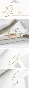 Detail view of 2mm knotted stainless steel bangle with 1cm round letter pendant