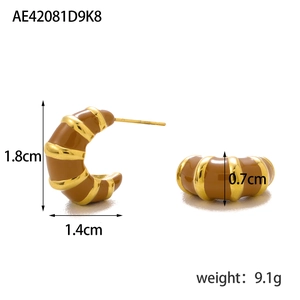 Macro side view of vintage C-shape enamel hoop earrings with gold striped accents