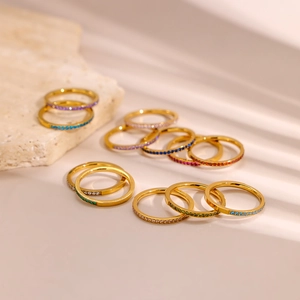 Dettaglio macro di anelli impilabili placcati oro 18K con zirconi multicolori a pavé