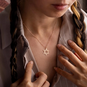 Dettaglio di una collana con ciondolo Stella di David placcata in oro 18K sul collo