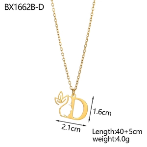 Detailed view of 18K gold letter D pendant with face outline and vine design