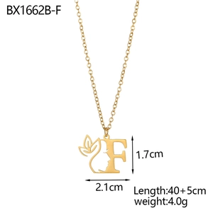 Detail view of 18K gold plated stainless steel letter F pendant with face and floral motifs