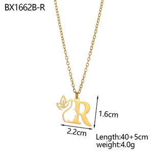 Close-up of golden letter R pendant with floral vine and face silhouette details