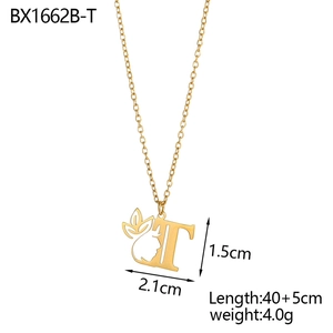 Detail view of 18K gold letter T pendant necklace with face outline and vine leaf motifs