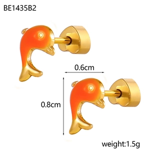 Détail macro de la boucle d'oreille dauphin montrant l'émail orange et la taille de 0,8 cm