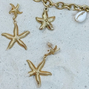 Orecchini a stella marina e bracciale placcato oro 14K con conchiglia sulla sabbia bianca