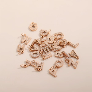 Macro shot of rose gold paved zircon letter pendants with integrated top hanging loops