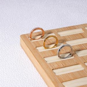 Close-up of gold silver and rose gold spinner rings with cubic zirconia on wood tray