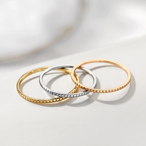 Set of three minimalist textured rings in gold, silver, and rose gold finishes