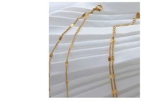 Primer plano de cadena bañada en oro 18K con cierre de langosta y lentejuelas en seda