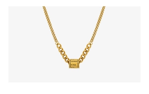 Vue détaillée d'une chaîne cubaine dorée avec un pendentif cylindrique gravé pour femme