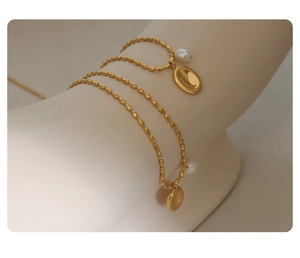 Detailansicht einer Vintage-Goldperlenkette mit ovalem Anhänger und echter Süßwasserperle