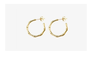 Macro detail of gold-plated bamboo joint hoop earrings showing texture and needle clasp