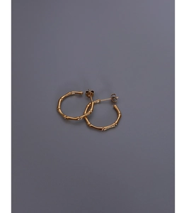 Detailed close-up of gold bamboo-textured C-shape hoop earrings in titanium steel