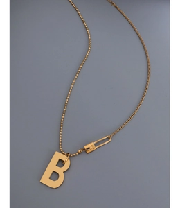 Détail du collier doré avec pendentif B et fermoir gravé LOVE sur fond gris