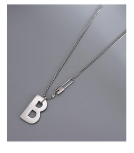 Vue détaillée du pendentif B en titane plaqué or 18 carats et du fermoir en épingle LOVE