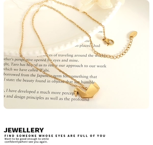 Primer plano de collar con colgante de cisne origami dorado y etiqueta grabada K18